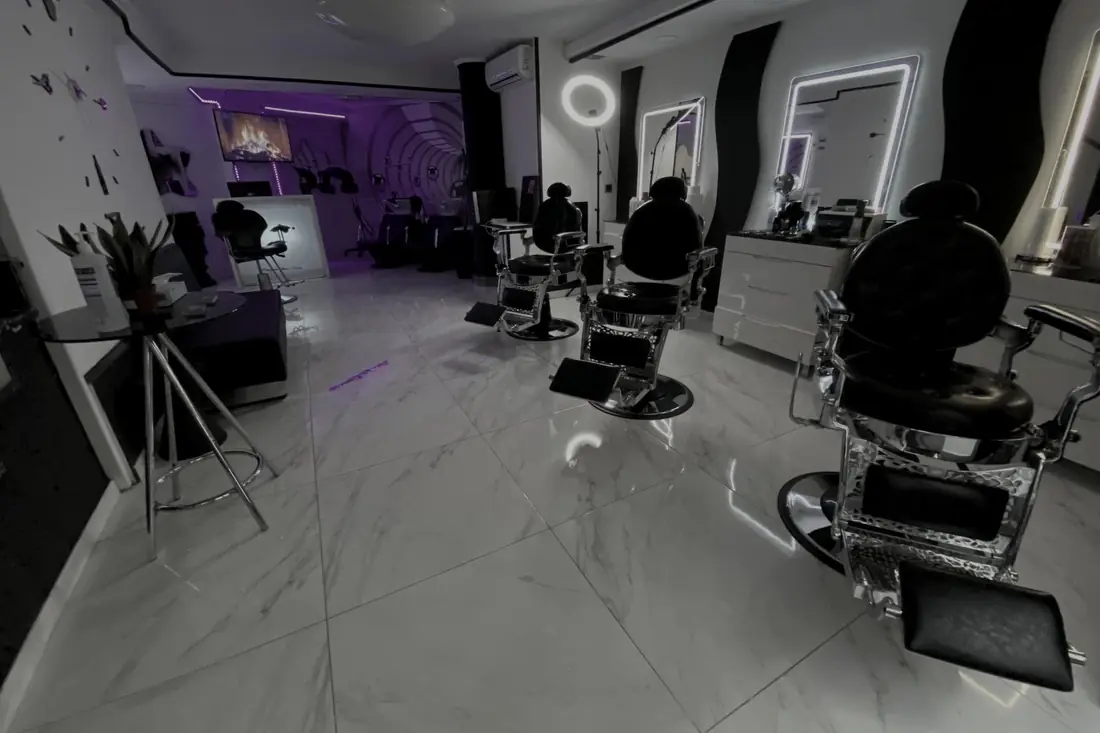 Interior de Black & White VIP: sillones de barbero, espejos y suelo de mármol