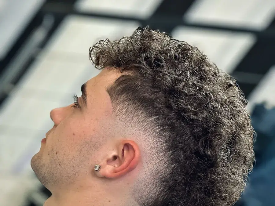 Fade en pelo canoso y rizado con textura marcada